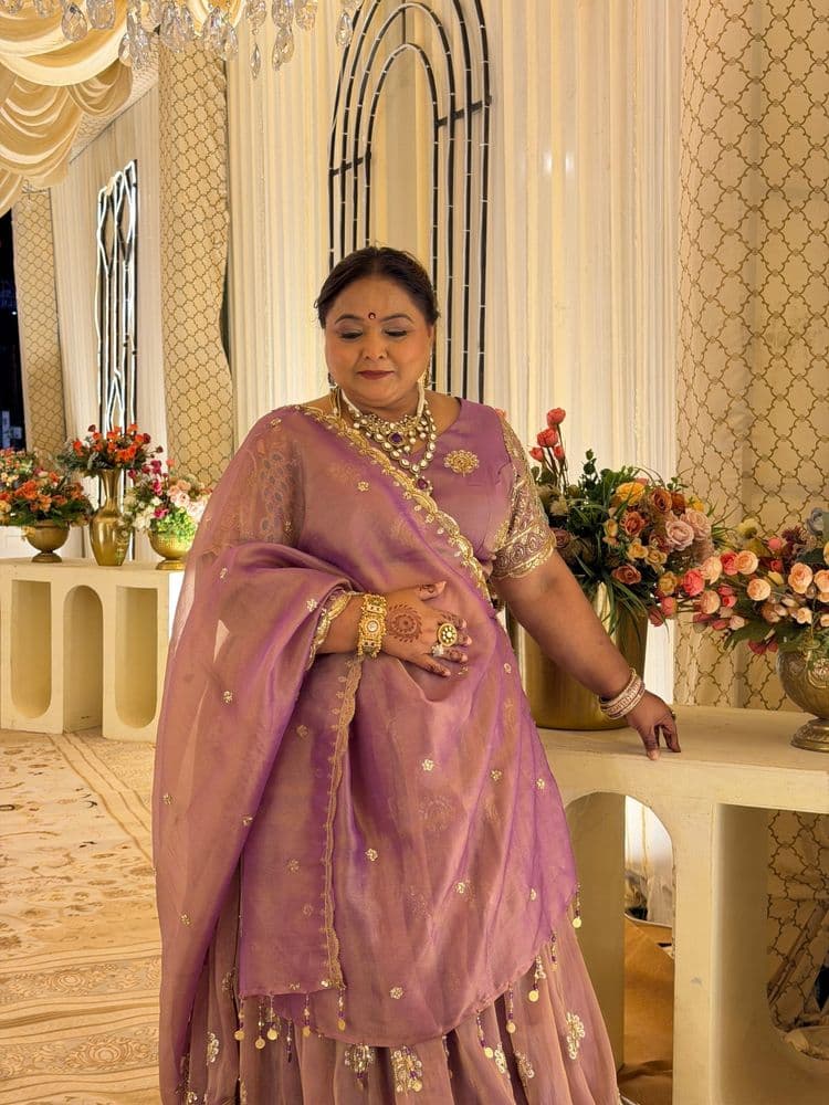 Woman in a mauve and lilac organza lehenga-saree, photographed at a floral mandap.